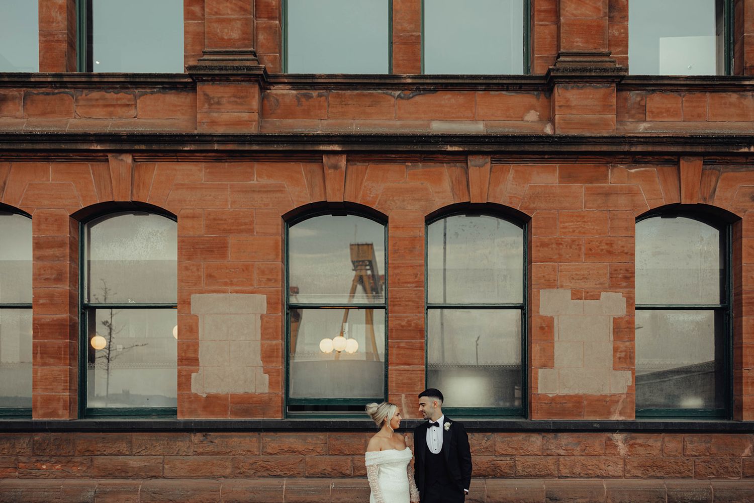 Exterior view of a historic red brick building with arched windows and ornate architectural details.