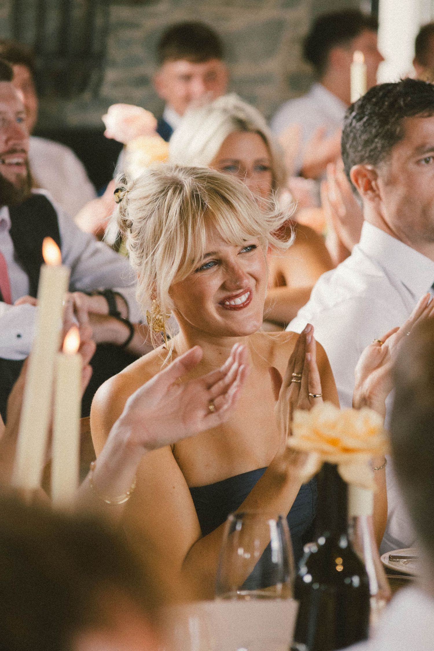 Wedding reception guests laughing and enjoying themselves at a celebratory dinner.