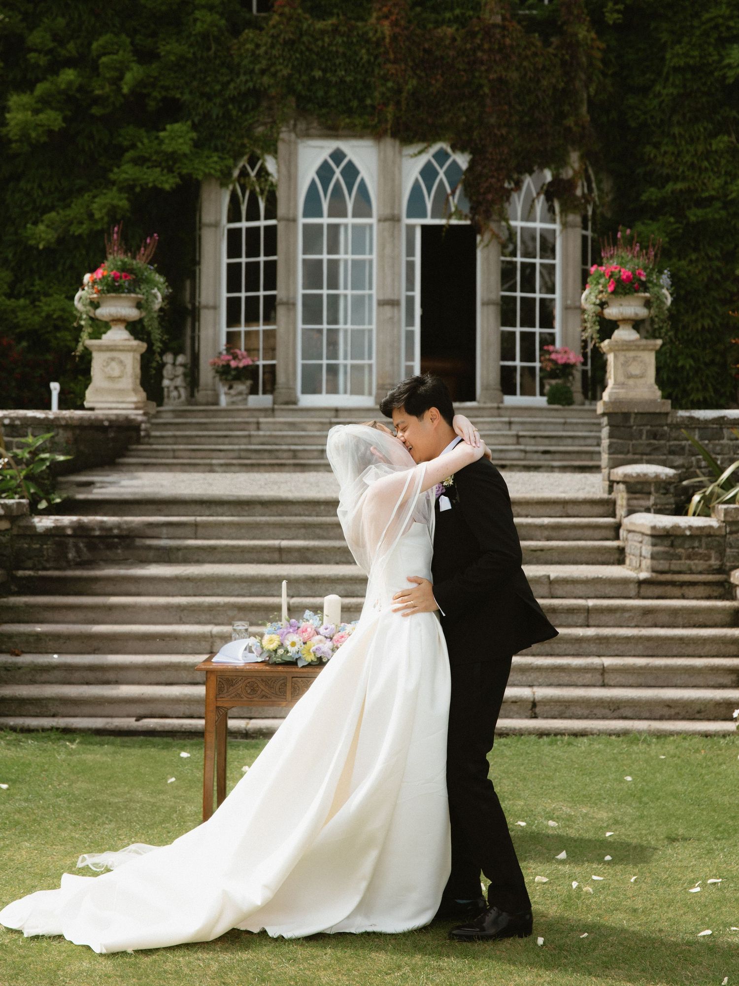 Romantic wedding moment captured in front of a grand architectural backdrop with stone steps.