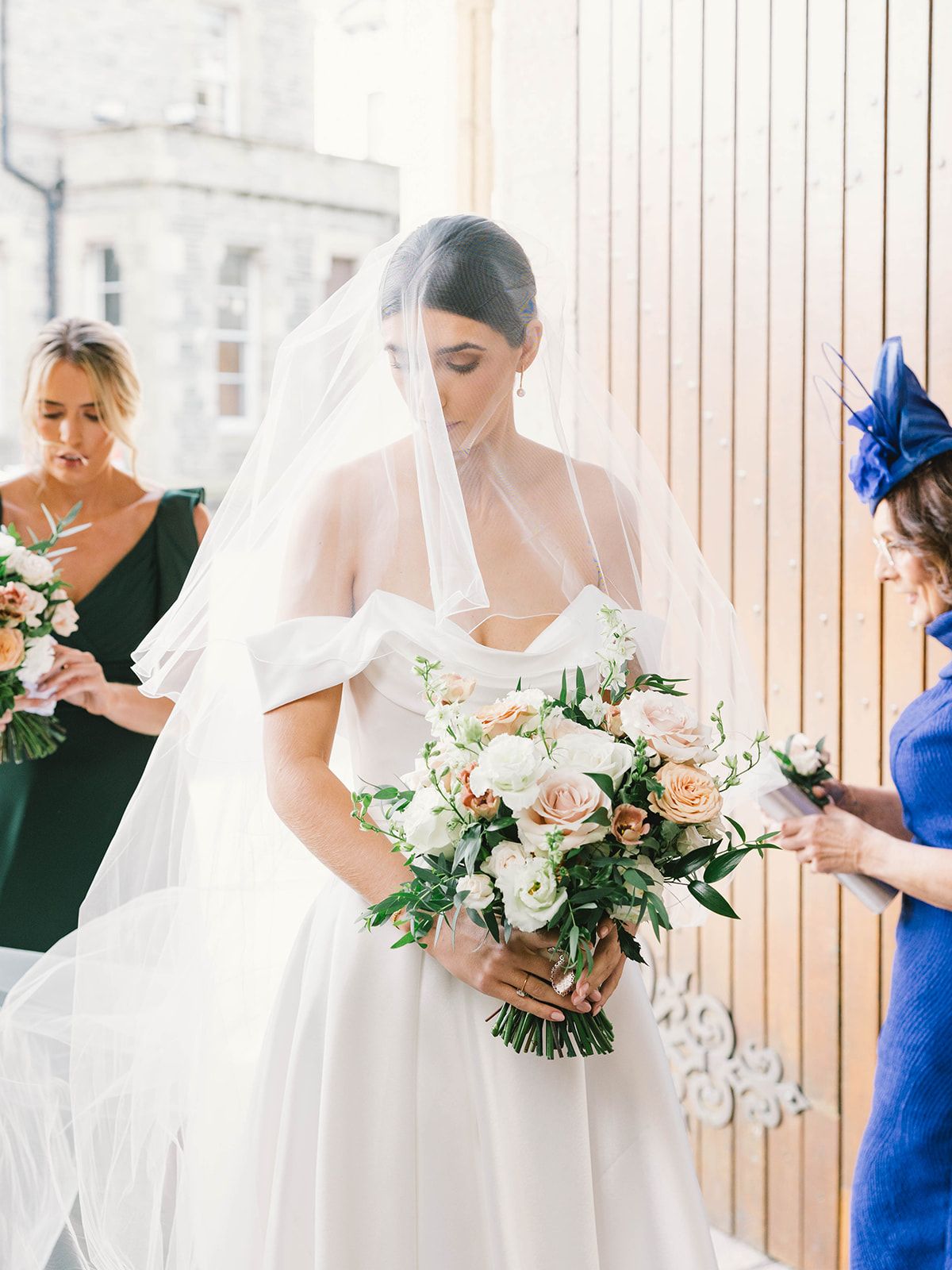 A delicate bridal scene with a white wedding gown and bouquet of blush and white flowers in an elegant setting.