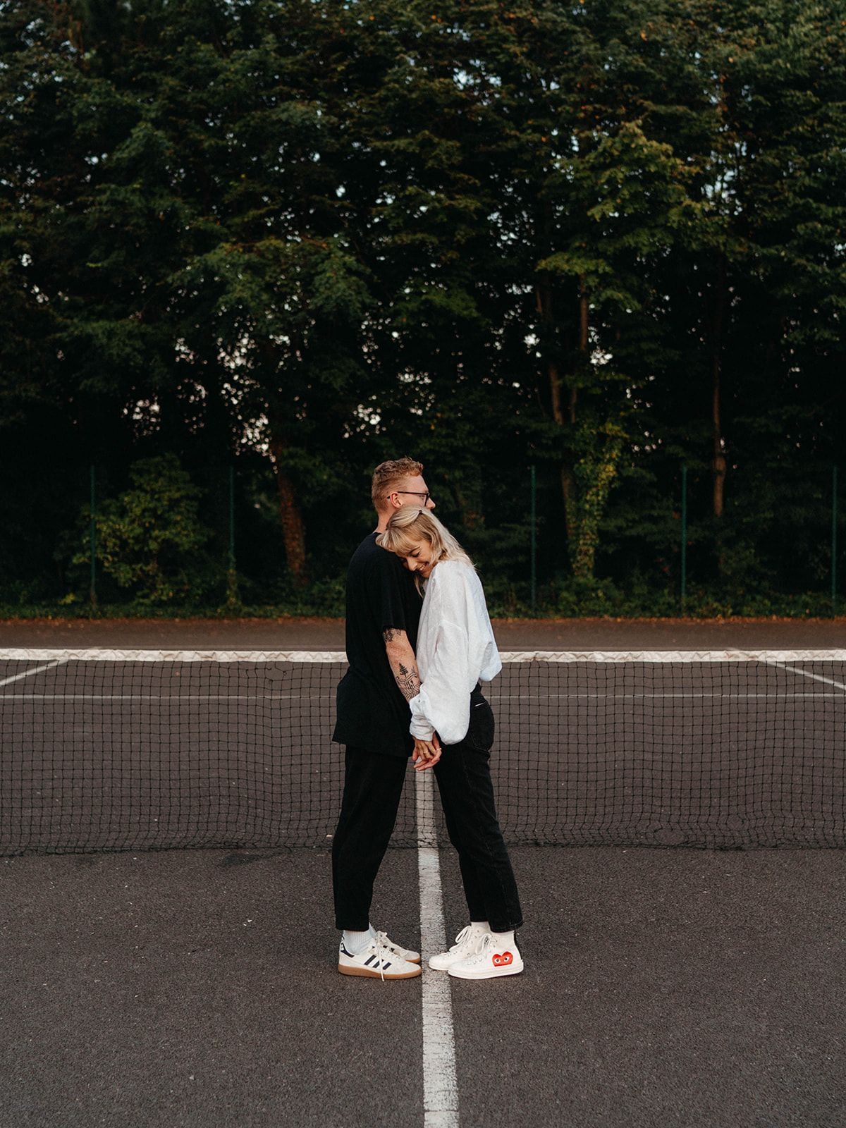 Artistic series of a couple standing together on a painted line in a parking lot.