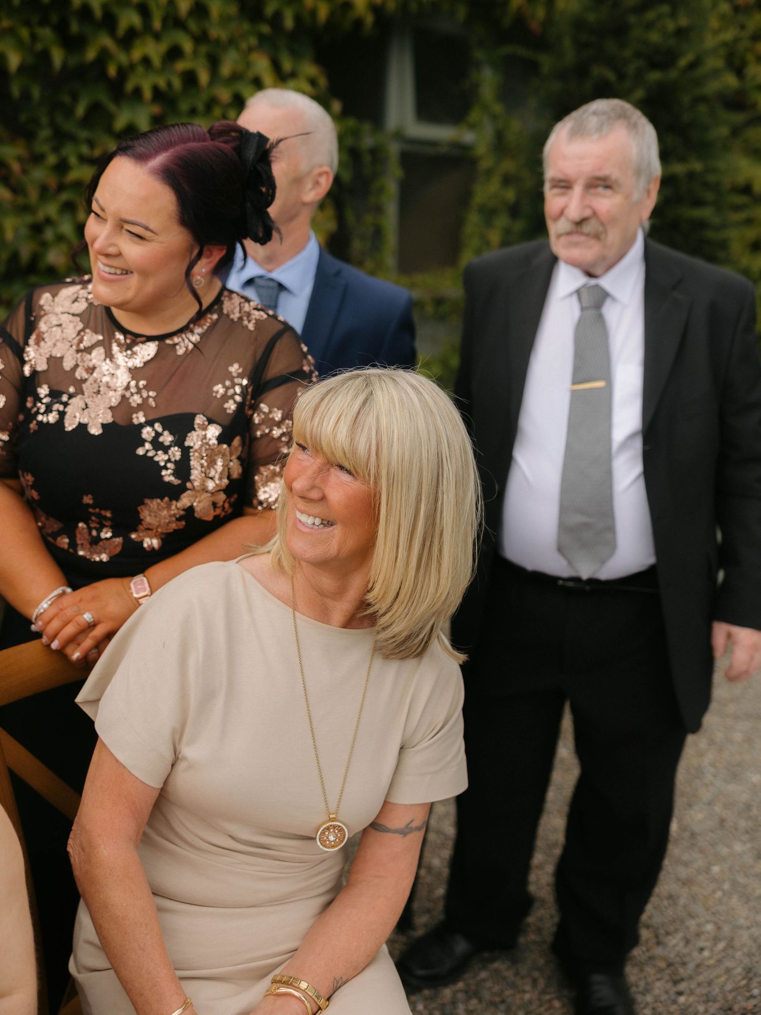 Wedding guests and family sharing laughs during outdoor celebration.