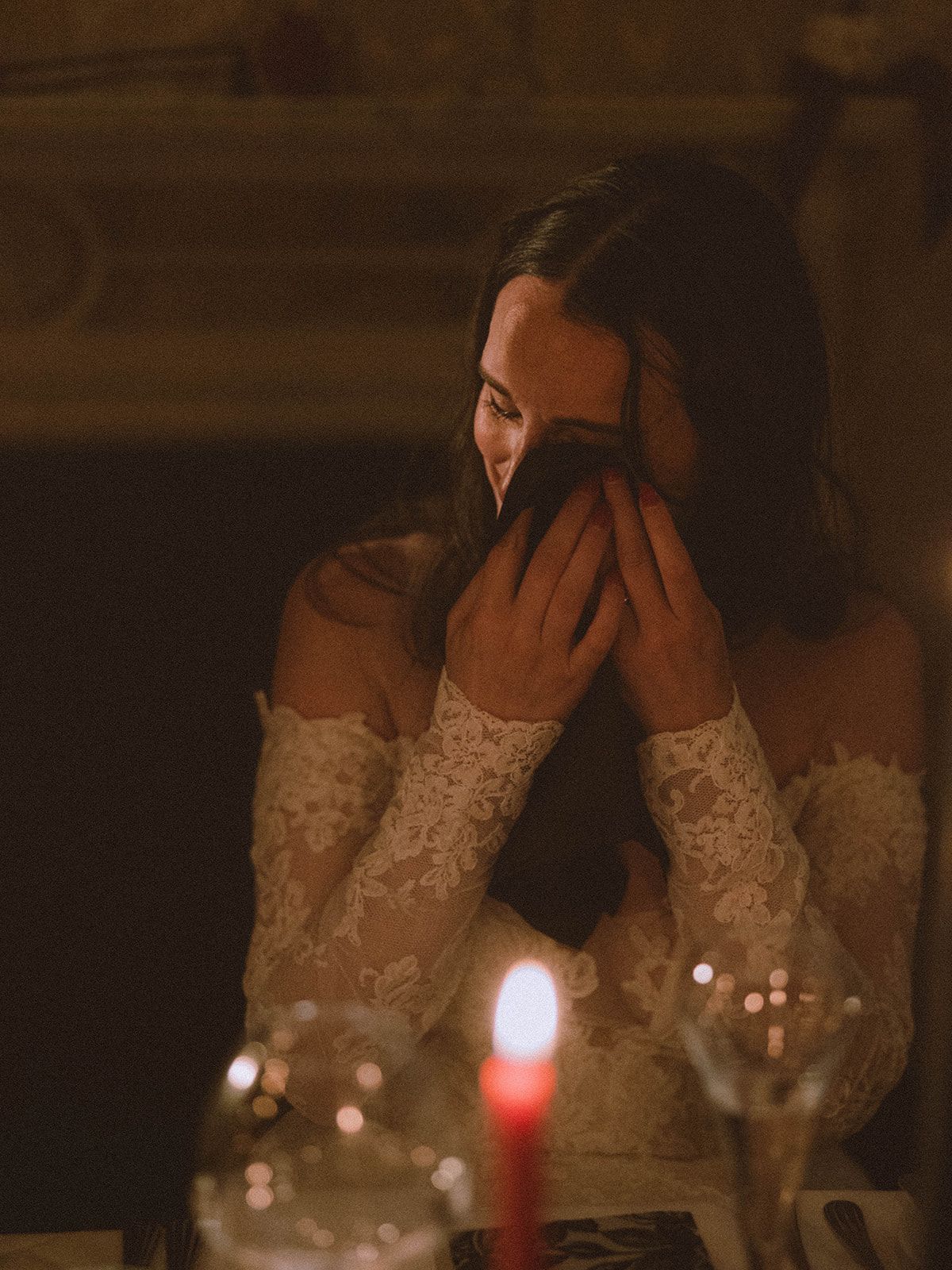 A romantic candlelit dinner setting with wine glasses and soft glowing ambiance in a dimly lit room.