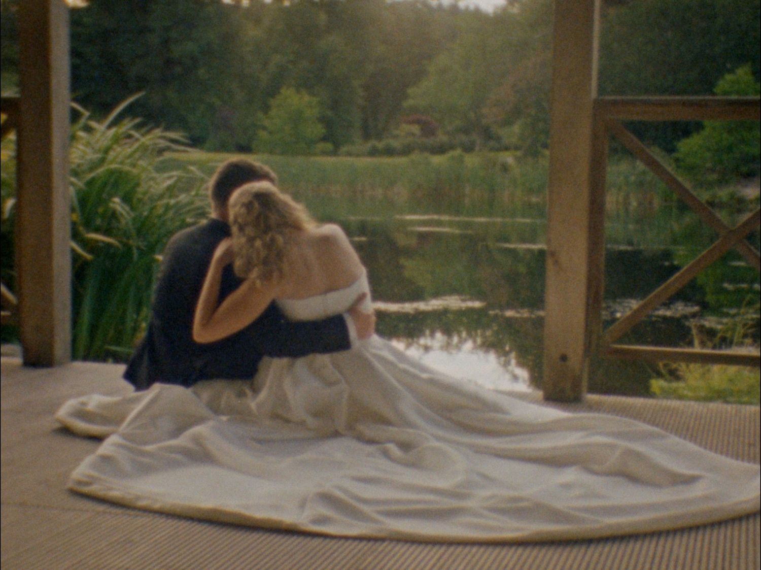 A series of romantic wedding photos captured by a lake with flowing white dress details.