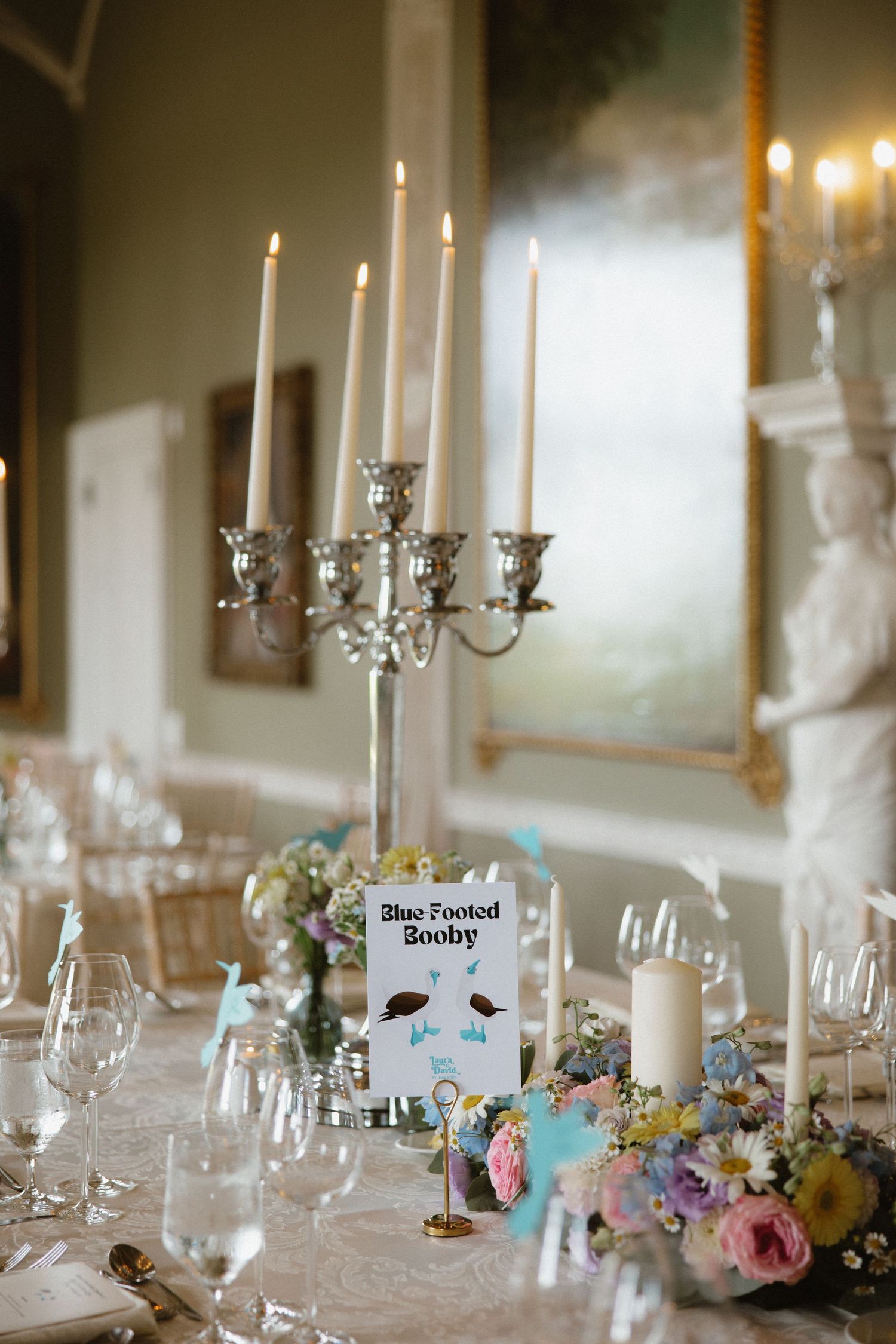 Elegant wedding reception table with silver candelabra, floral centerpieces and place cards.