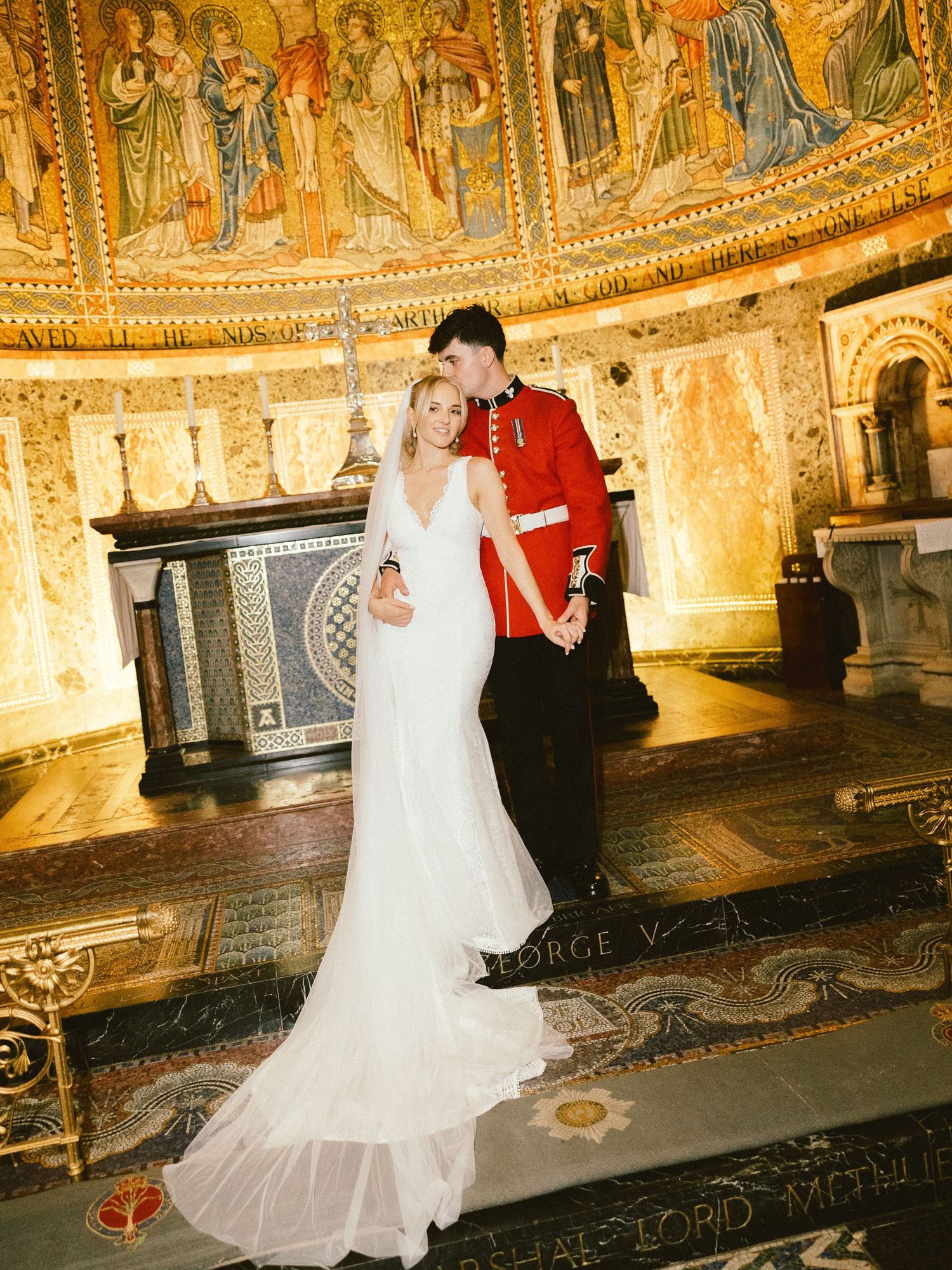 Newlywed couple dancing together in an elegant church with ornate golden mosaic walls and domed ceiling.