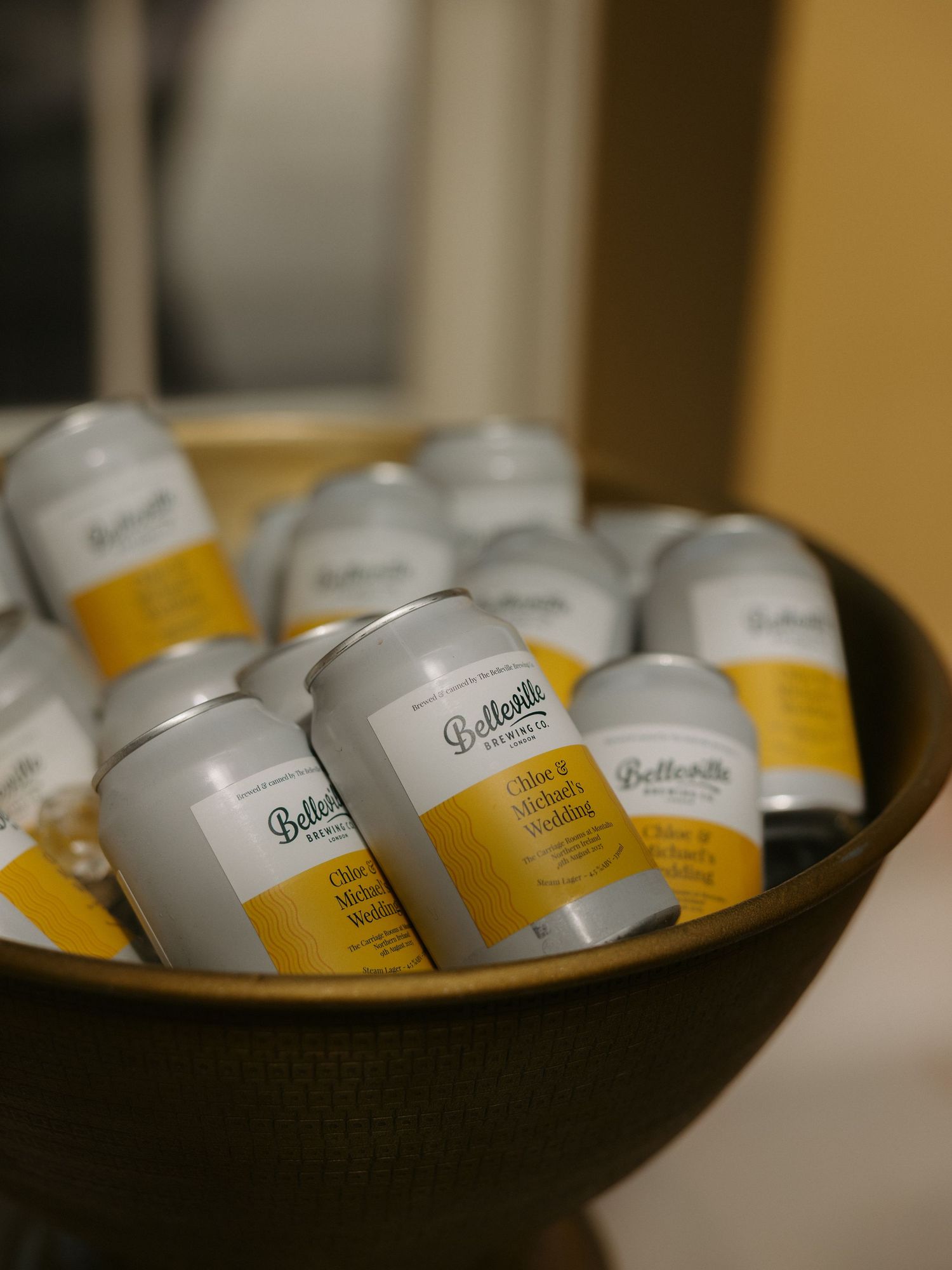 Small white cosmetic jars with yellow labels arranged on a dark surface in soft lighting.
