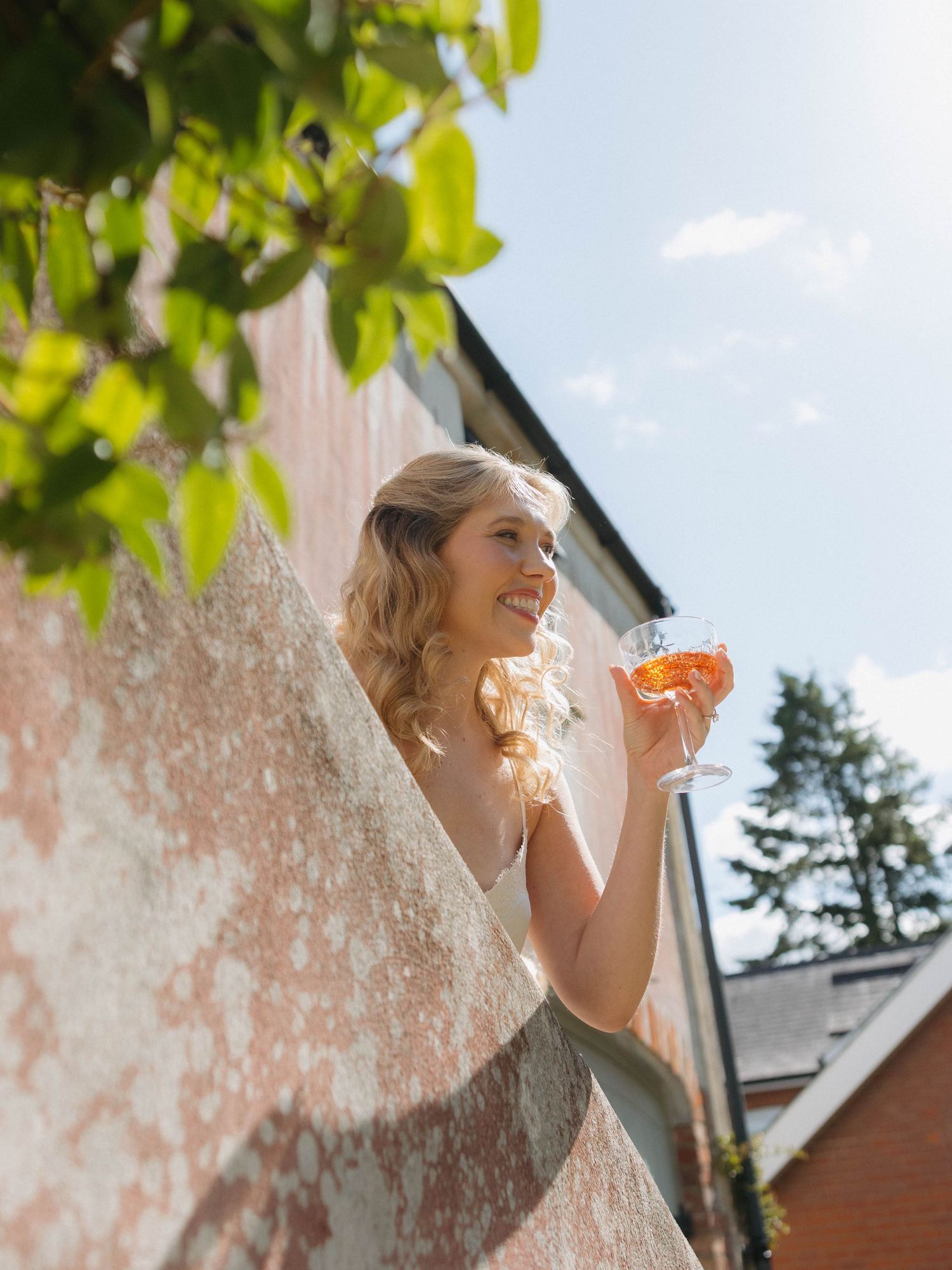 A joyful moment captured through lace curtains on a sunny wedding day.
