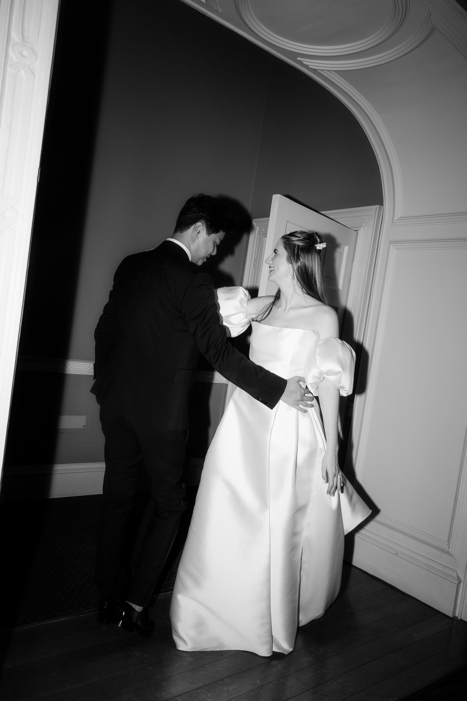 Black and white photo of a romantic dance moment in an elegant venue.