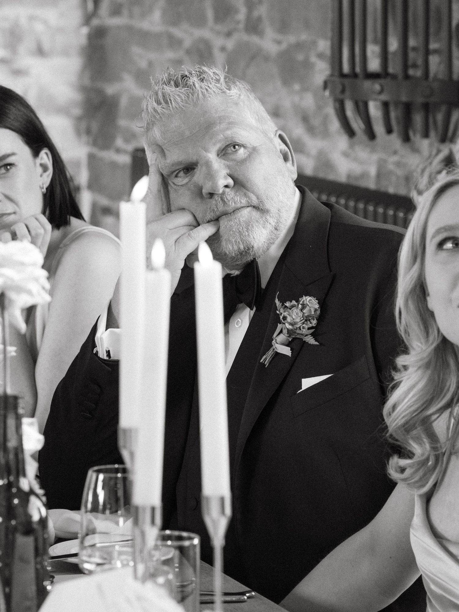 Candlelit wedding reception captures emotional moments between guests during speeches.