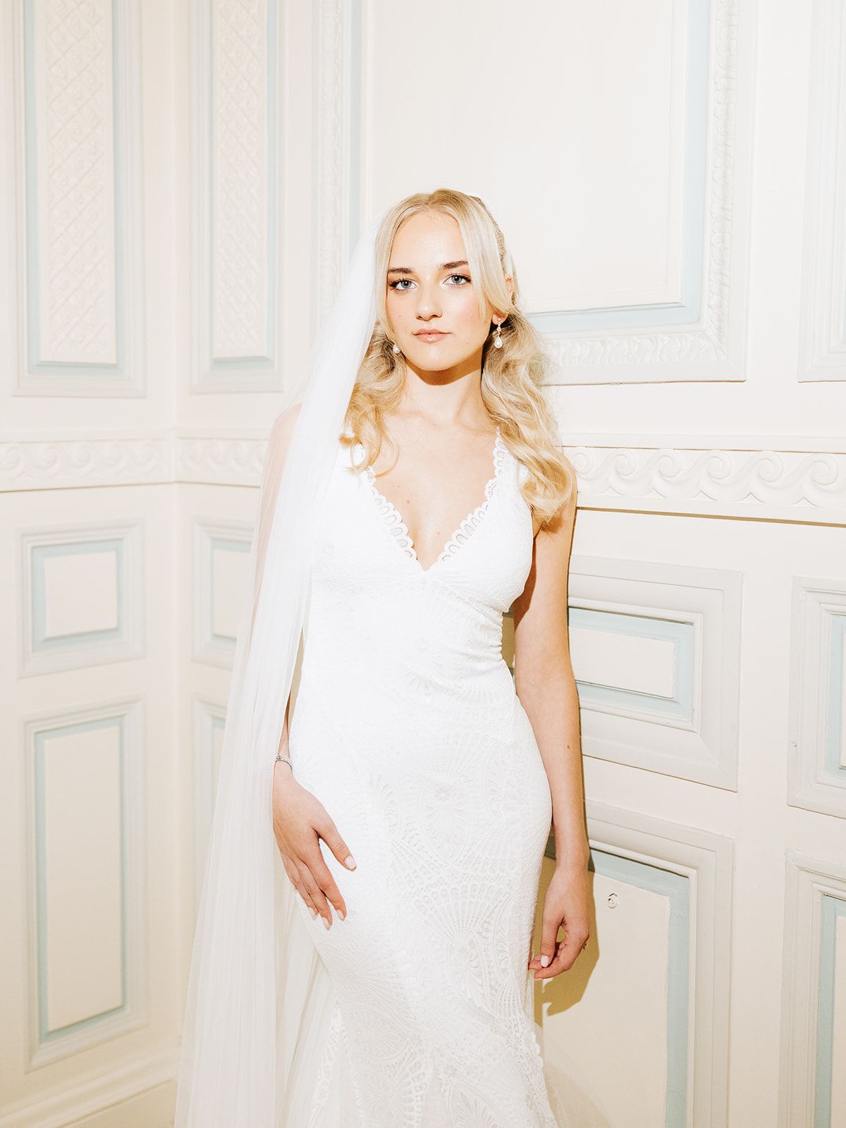 Three elegant photos of a woman in a white dress posing against a light-colored wall in a bright interior setting.