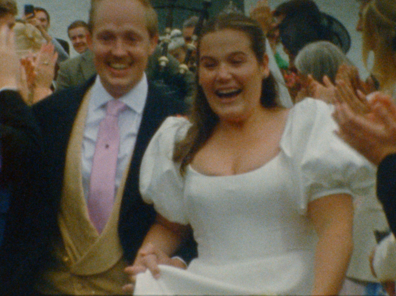A group of wedding guests celebrate and dance together during a joyful reception party.