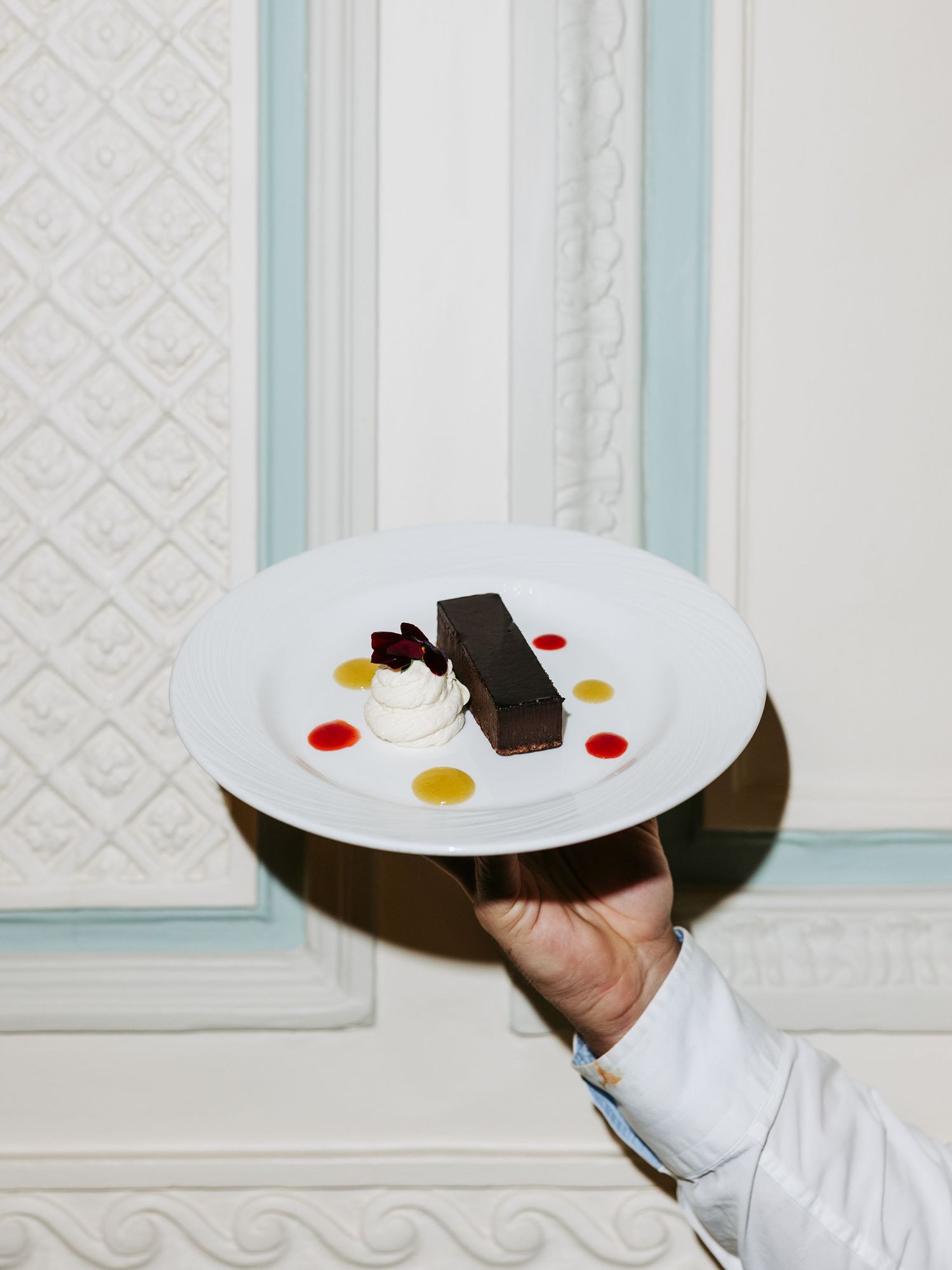 White dessert plates arranged in a sequence showing progressively eaten chocolate and fruit garnishes.
