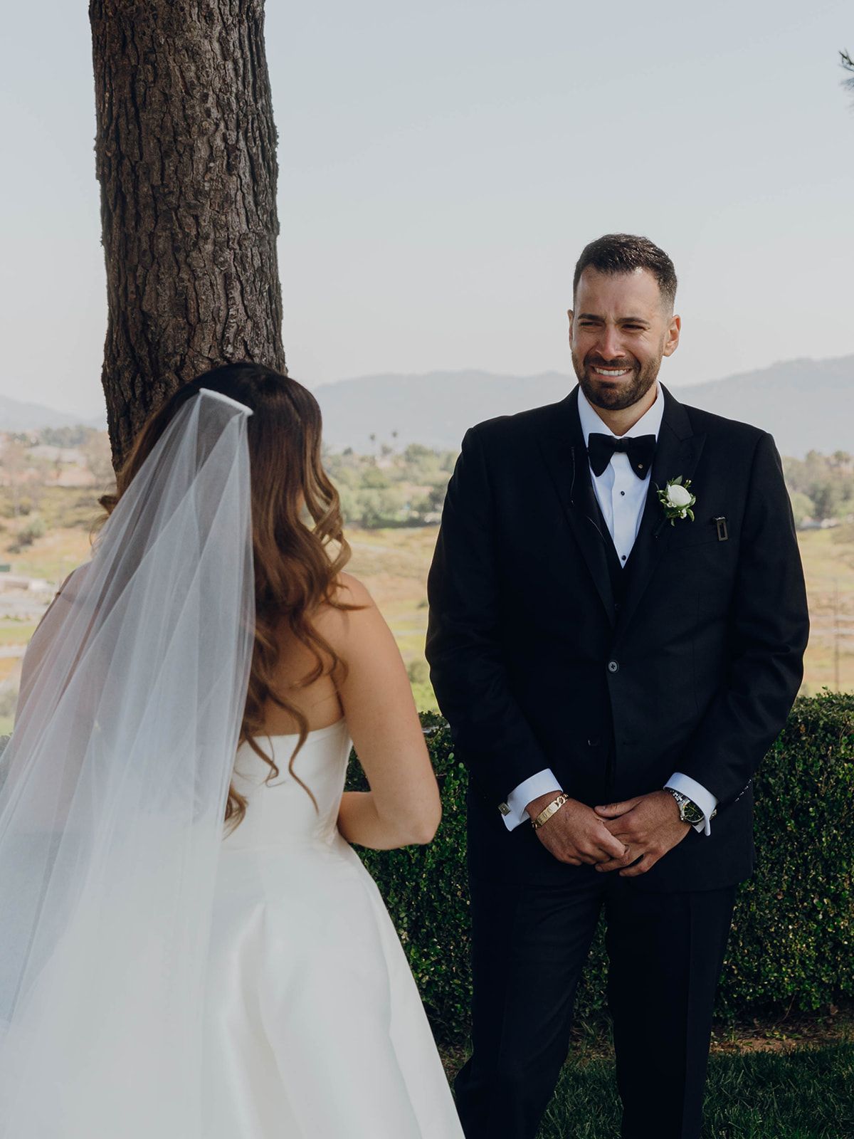 A couple shares a first look moment during their outdoor wedding ceremony with mountains in the background.