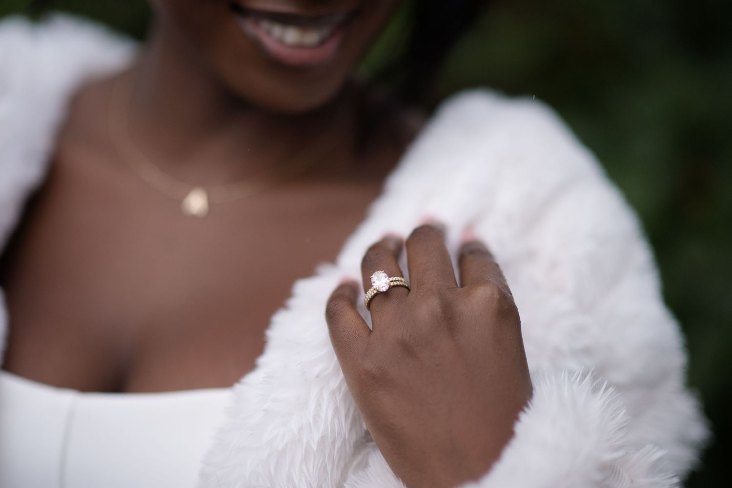 Close-up portrait of a joyful couple wearing white against a dark background.