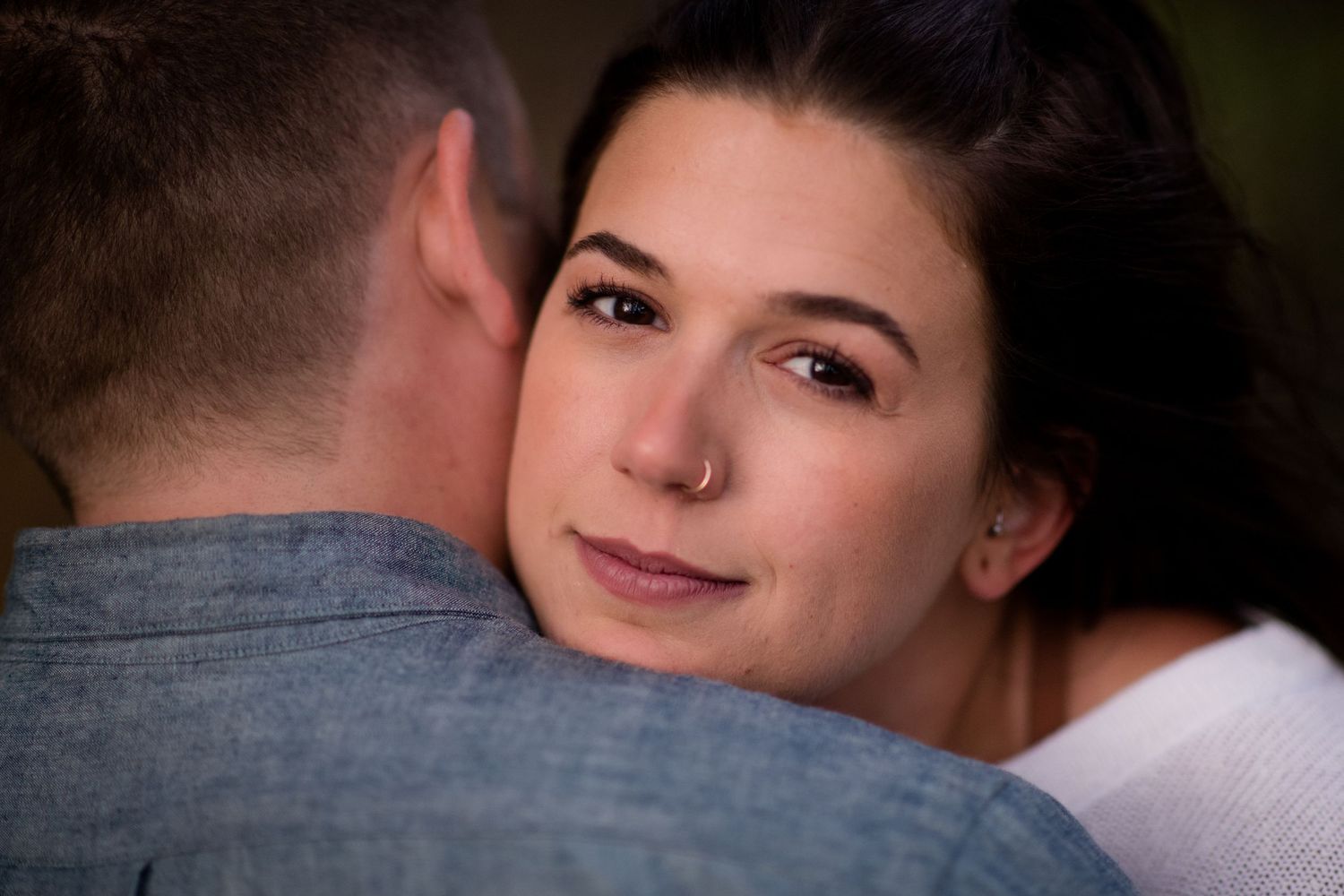 Close up portrait of a person leaning against another's shoulder.