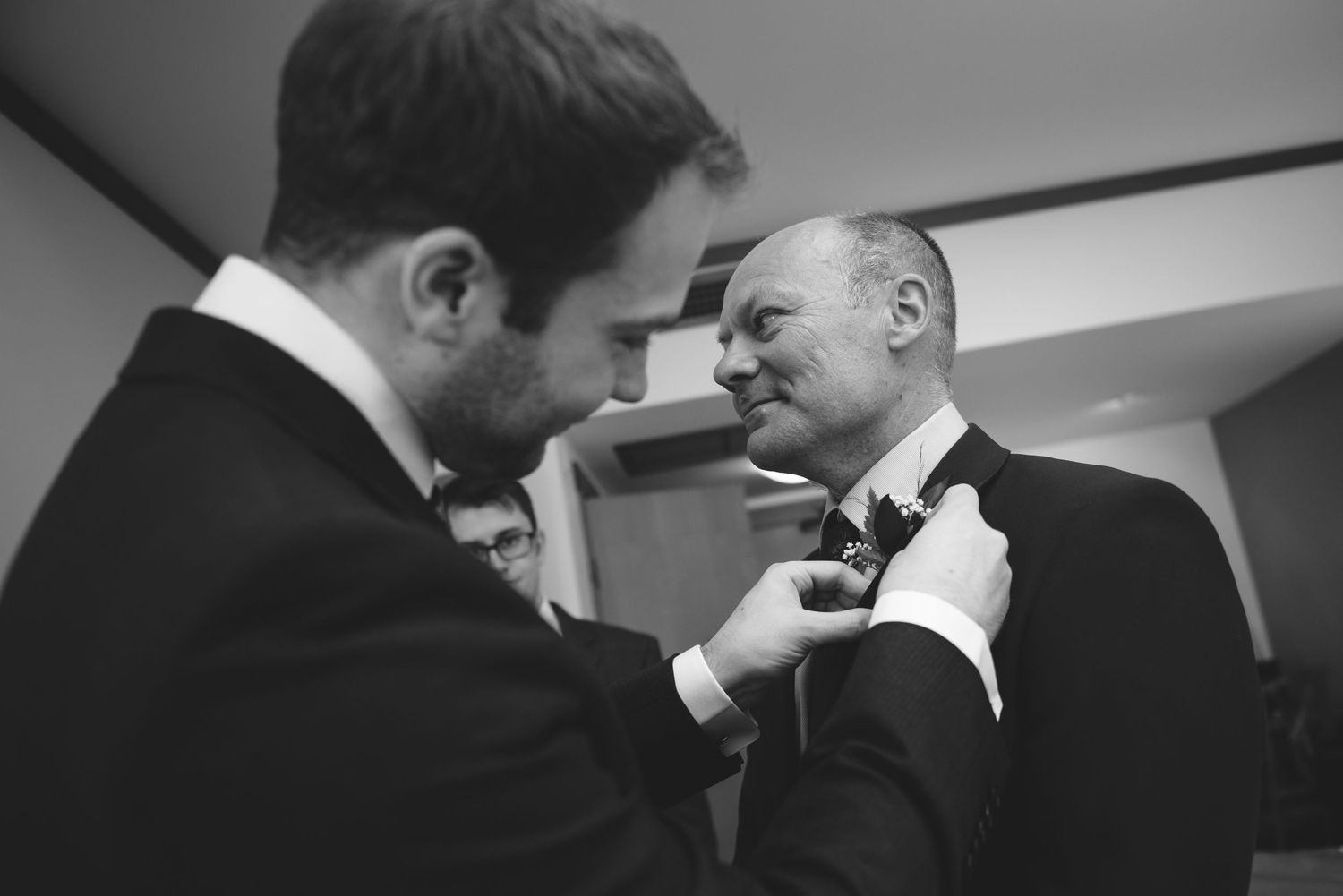 Men in formal attire prepare for a wedding ceremony.