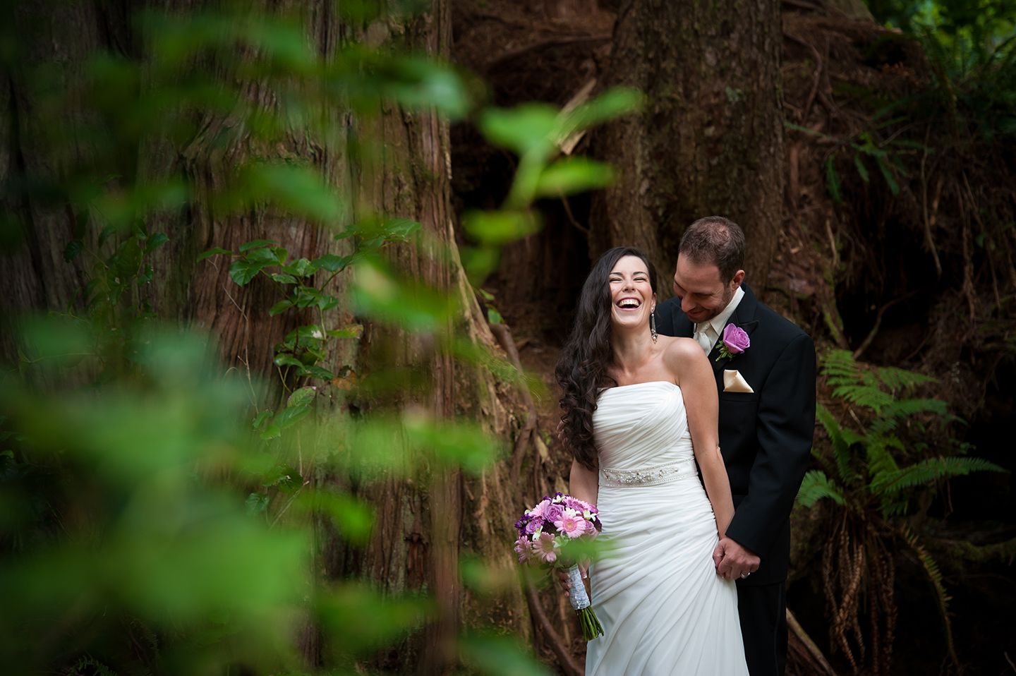 Romantic wedding moment captured in lush green forest setting.