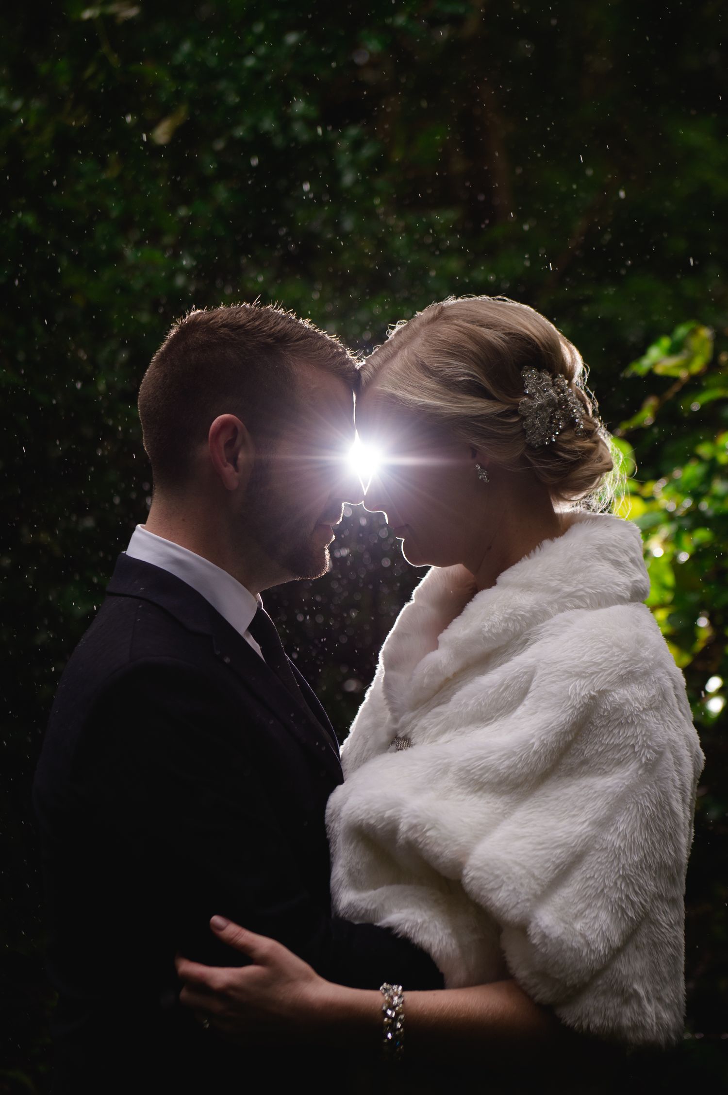 Romantic backlit evening wedding portraits with dramatic lighting effects.