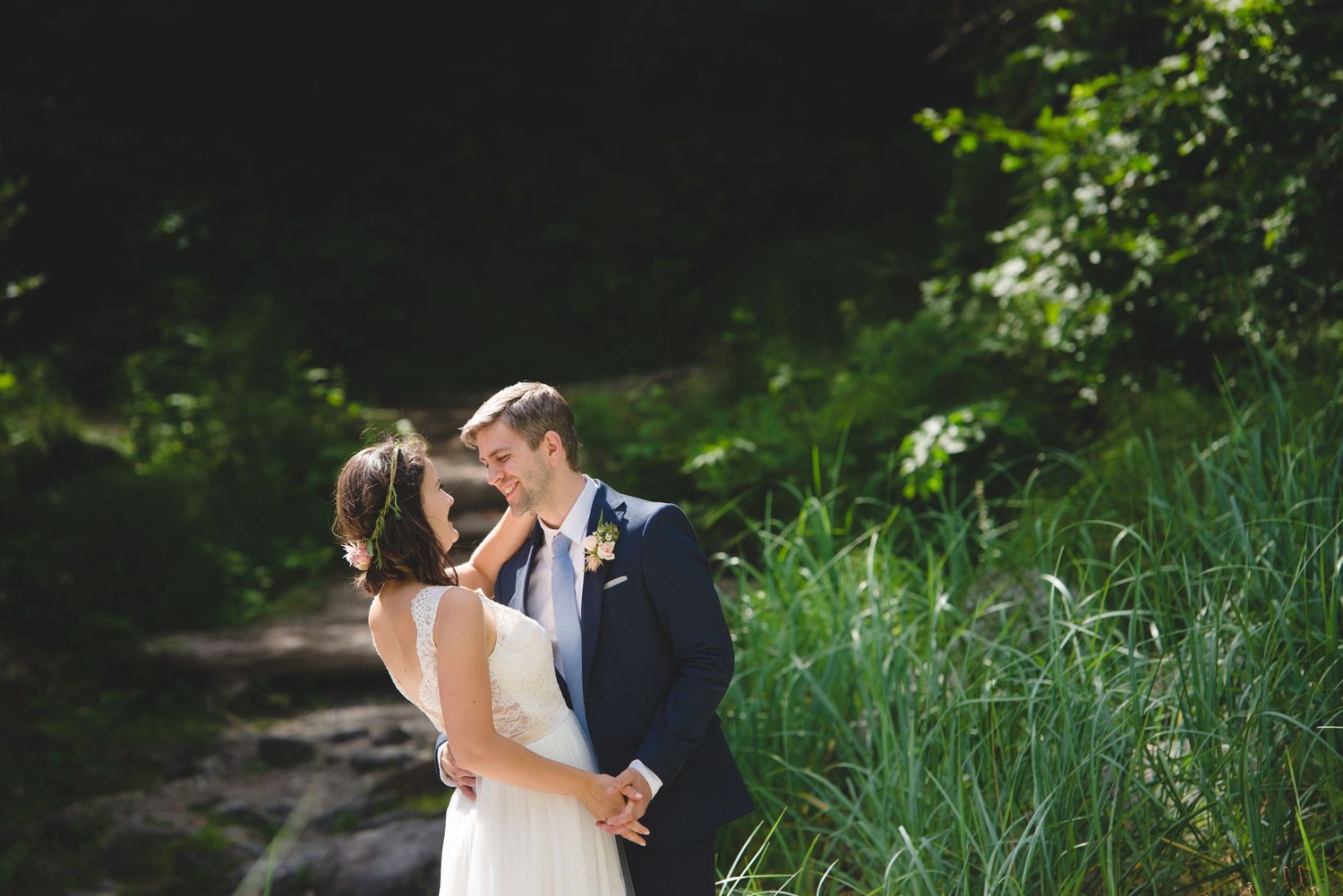 Wedding couple dancing in a lush green garden setting.
