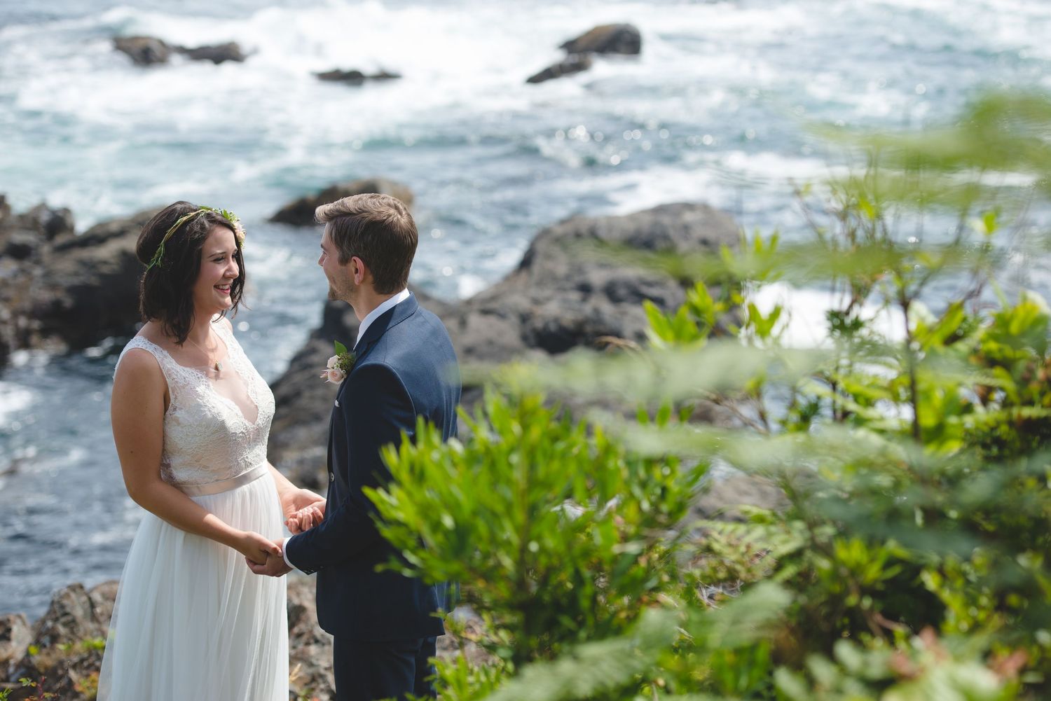 Wedding ceremony moments captured along a rugged coastline with crashing waves.
