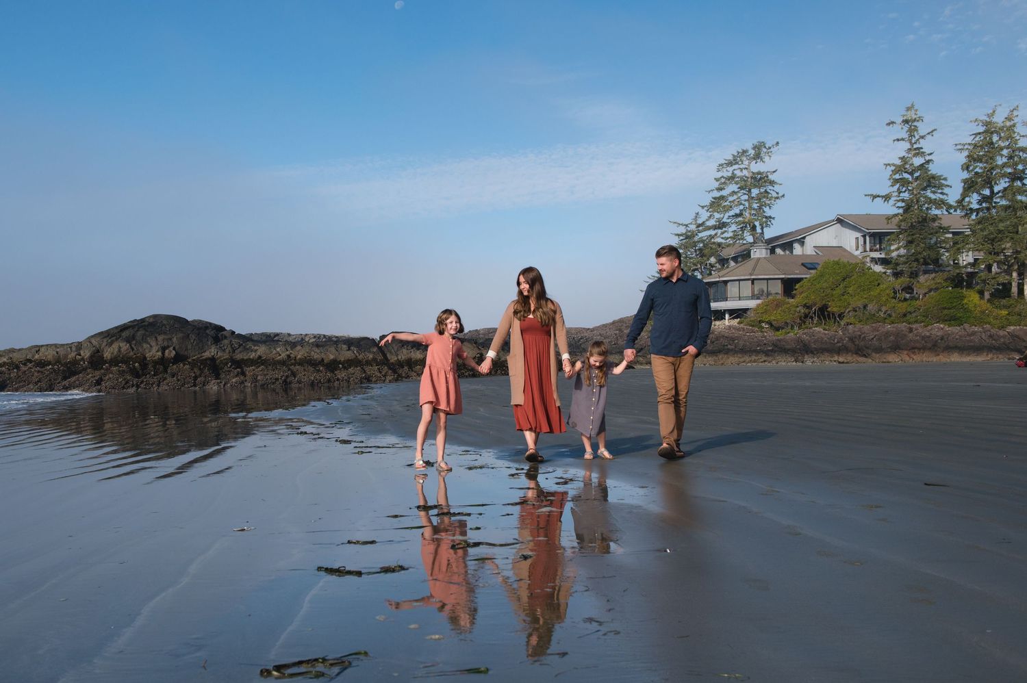 Group strolling along a foggy Pacific Northwest coastline at dusk.