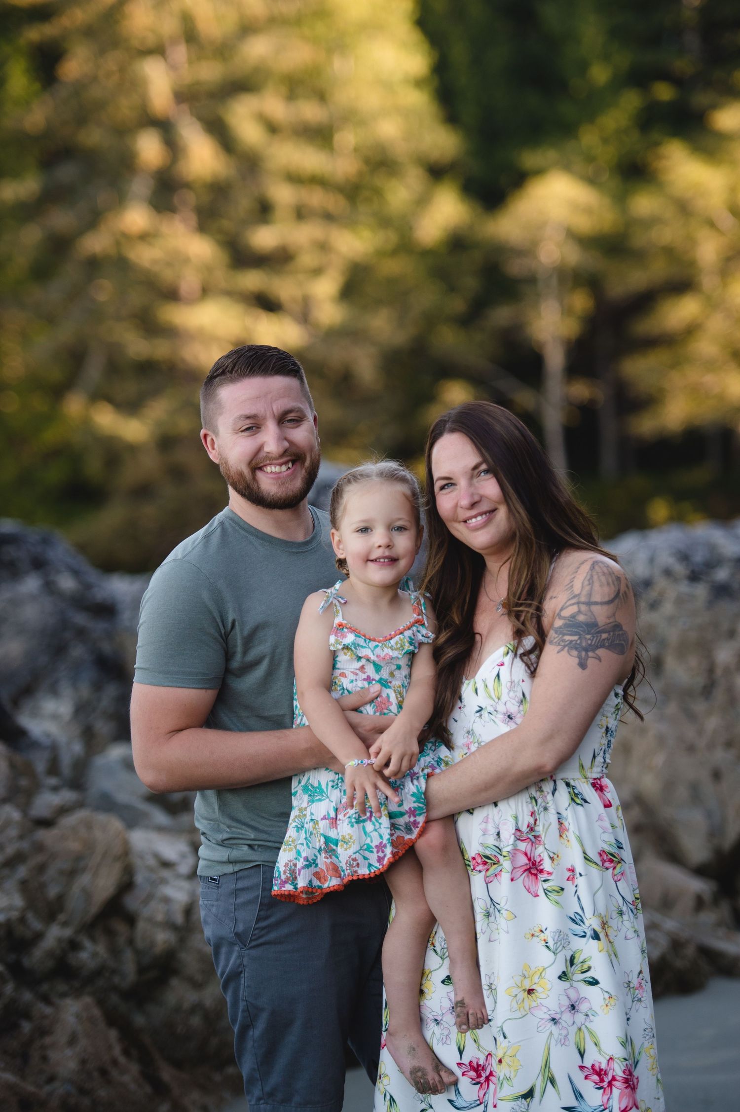 A happy family moment captured at sunset with rocky cliffs and forest in background.