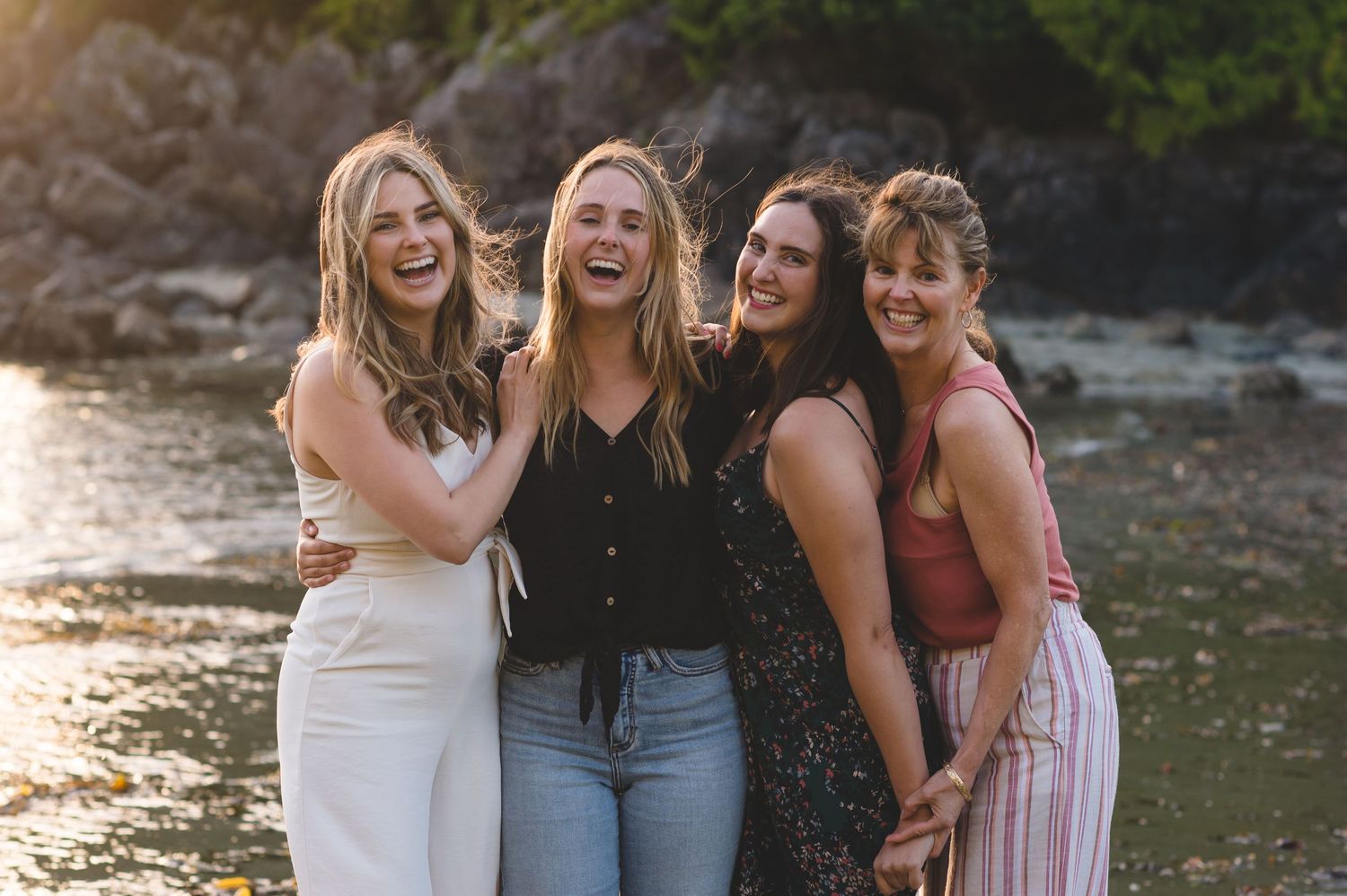 People gathered by a waterfront at sunset creating a joyful outdoor scene.