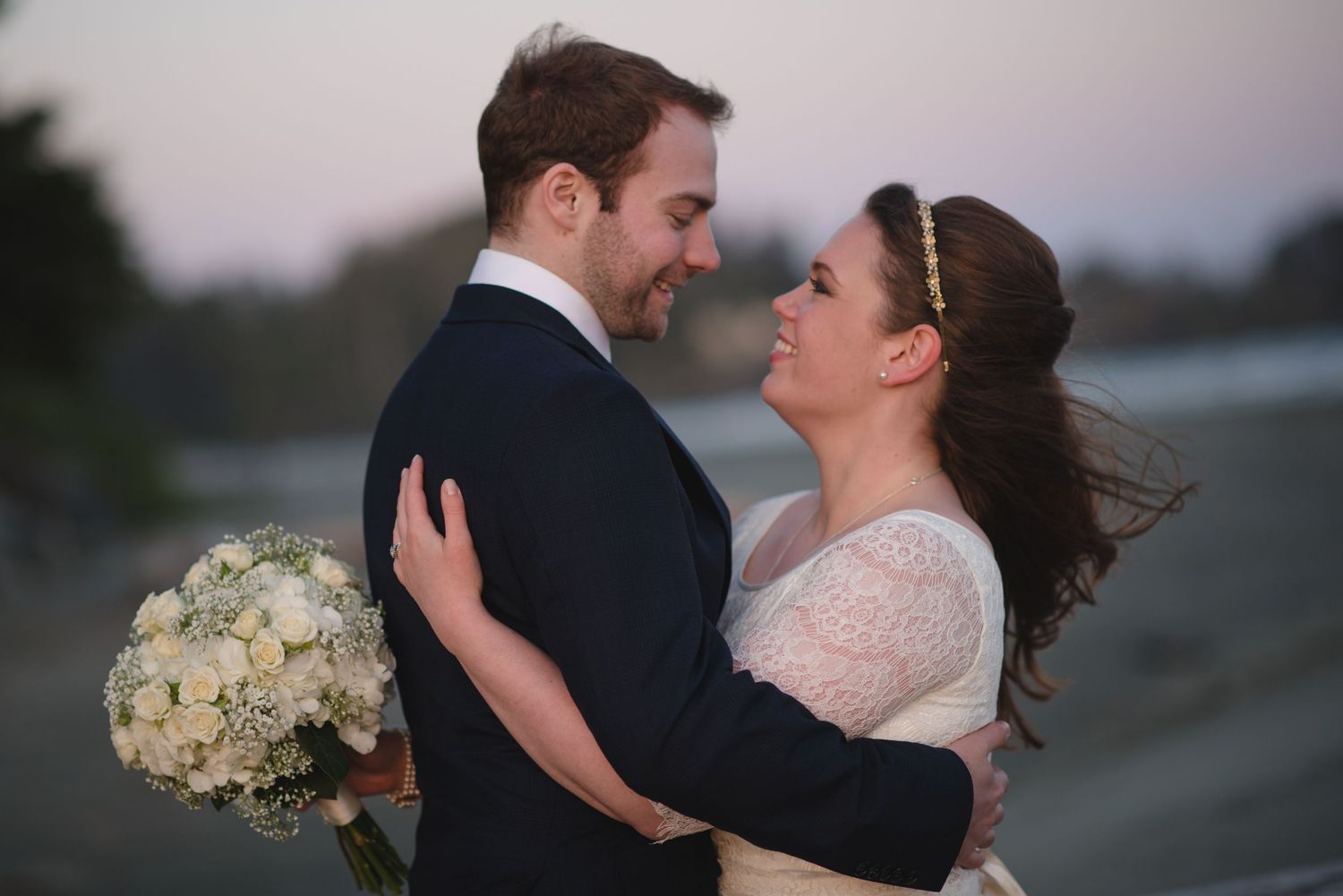 A joyful wedding moment captured as couple laughs together at sunset.