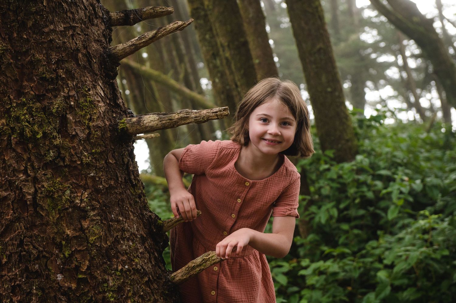 Family enjoying a playful moment together in a lush green forest setting.