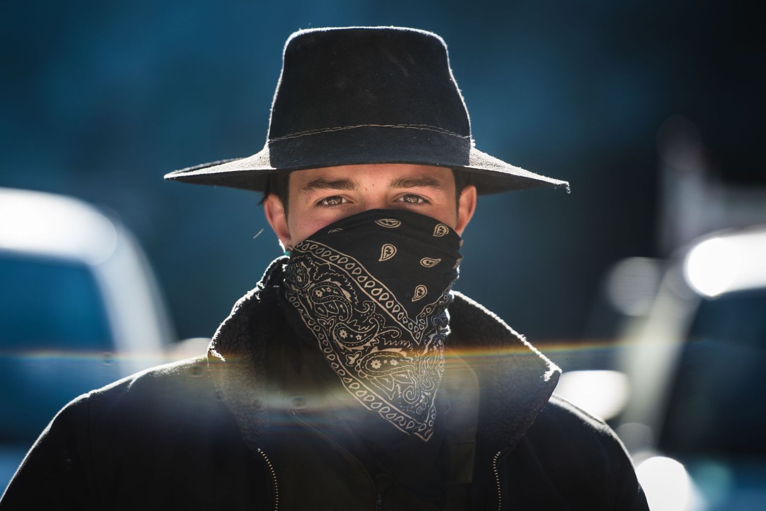 Fairy Creek blockade. Silhouettes of people wearing hats and bandanas against a dark blue background.