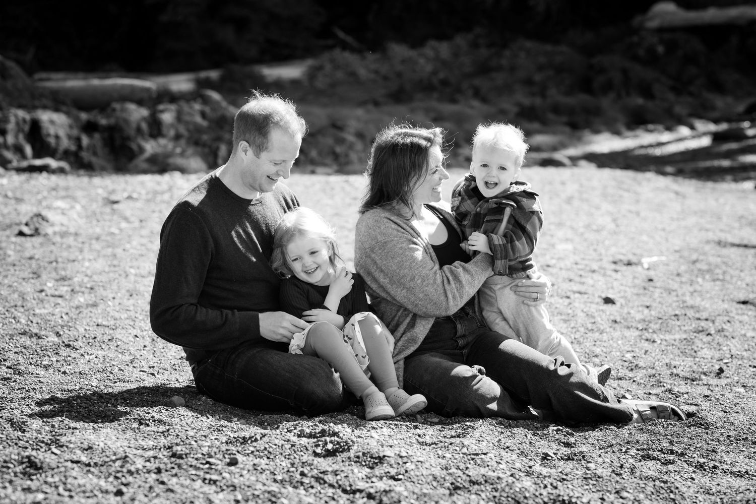 A black and white panoramic photo shows a family relaxing together outdoors on a sunny day.