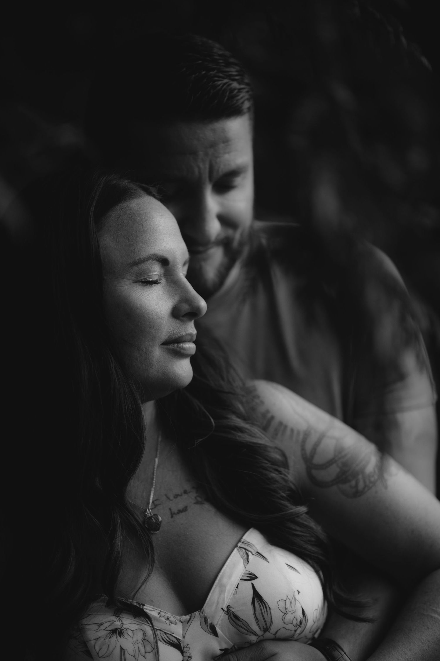 A dramatic black and white photo captures a couple's tender moment.