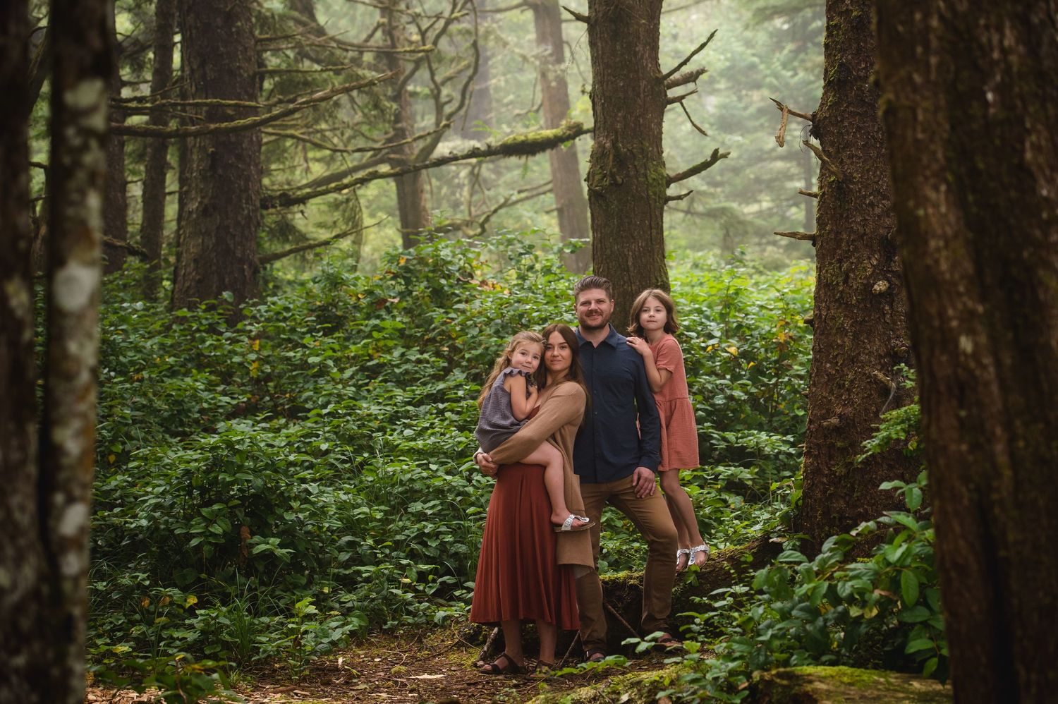 Group portrait session in a misty evergreen forest.