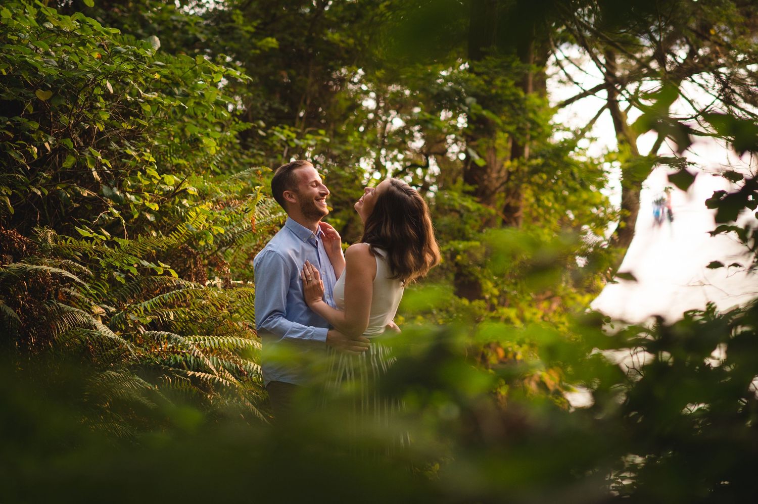 A romantic couple shares an intimate moment in a lush garden setting during golden hour sunlight.