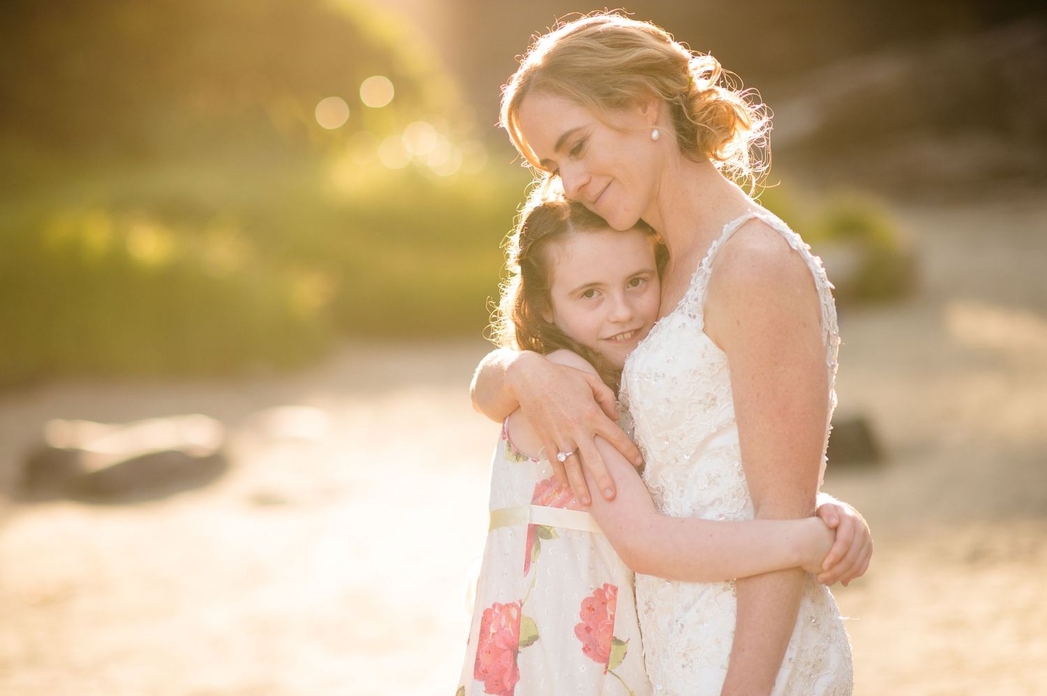 A tender moment captured in golden sunlight during a wedding celebration.