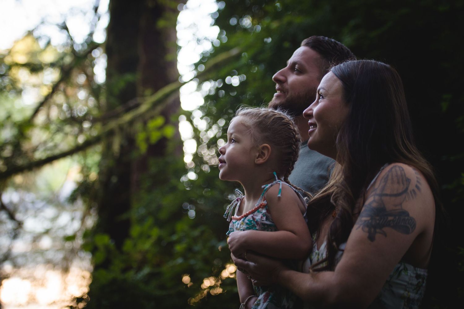 Group enjoying sunset views from wooden bridge in forest setting.