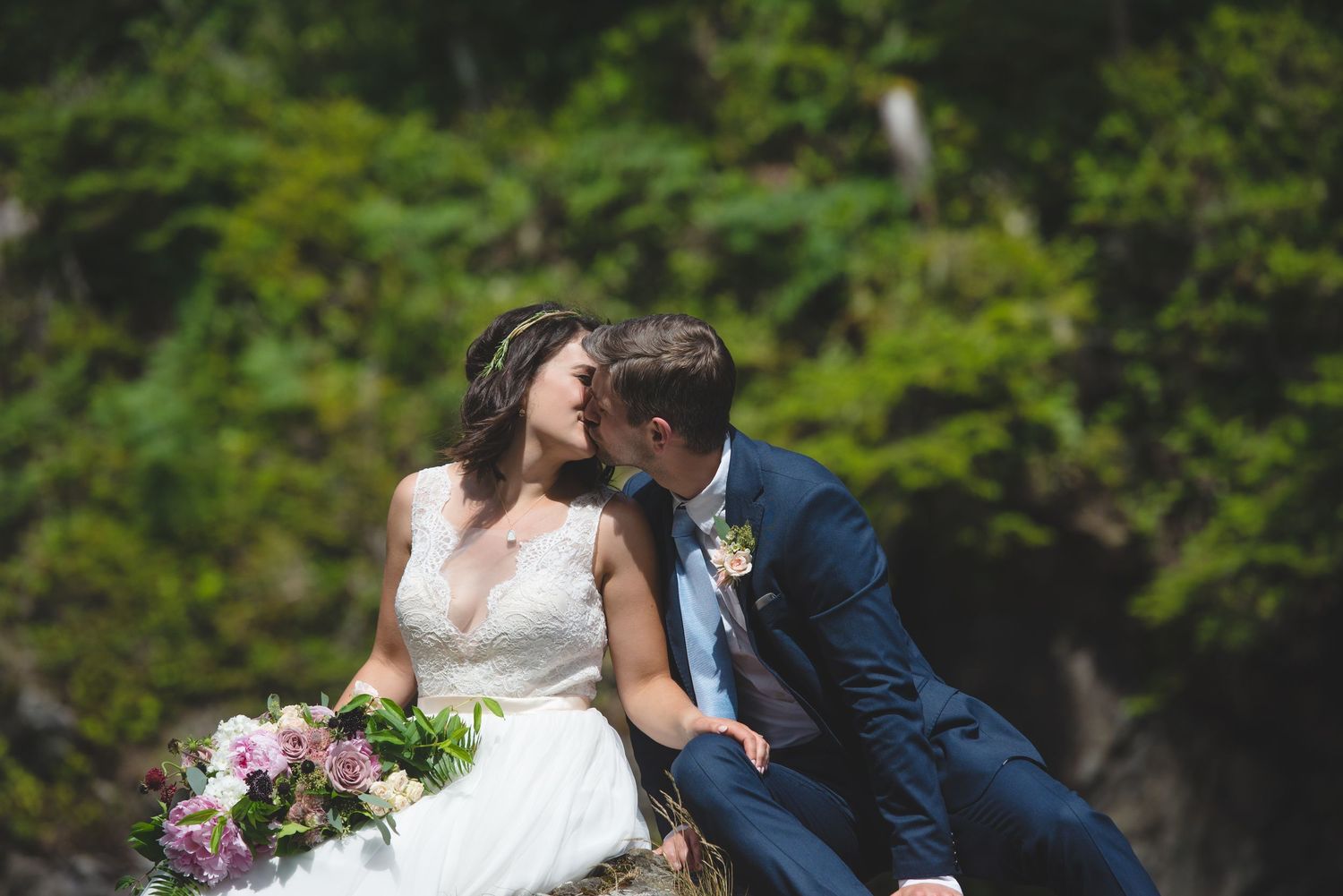 A romantic moment shared between a couple on rocky coastal cliffs.