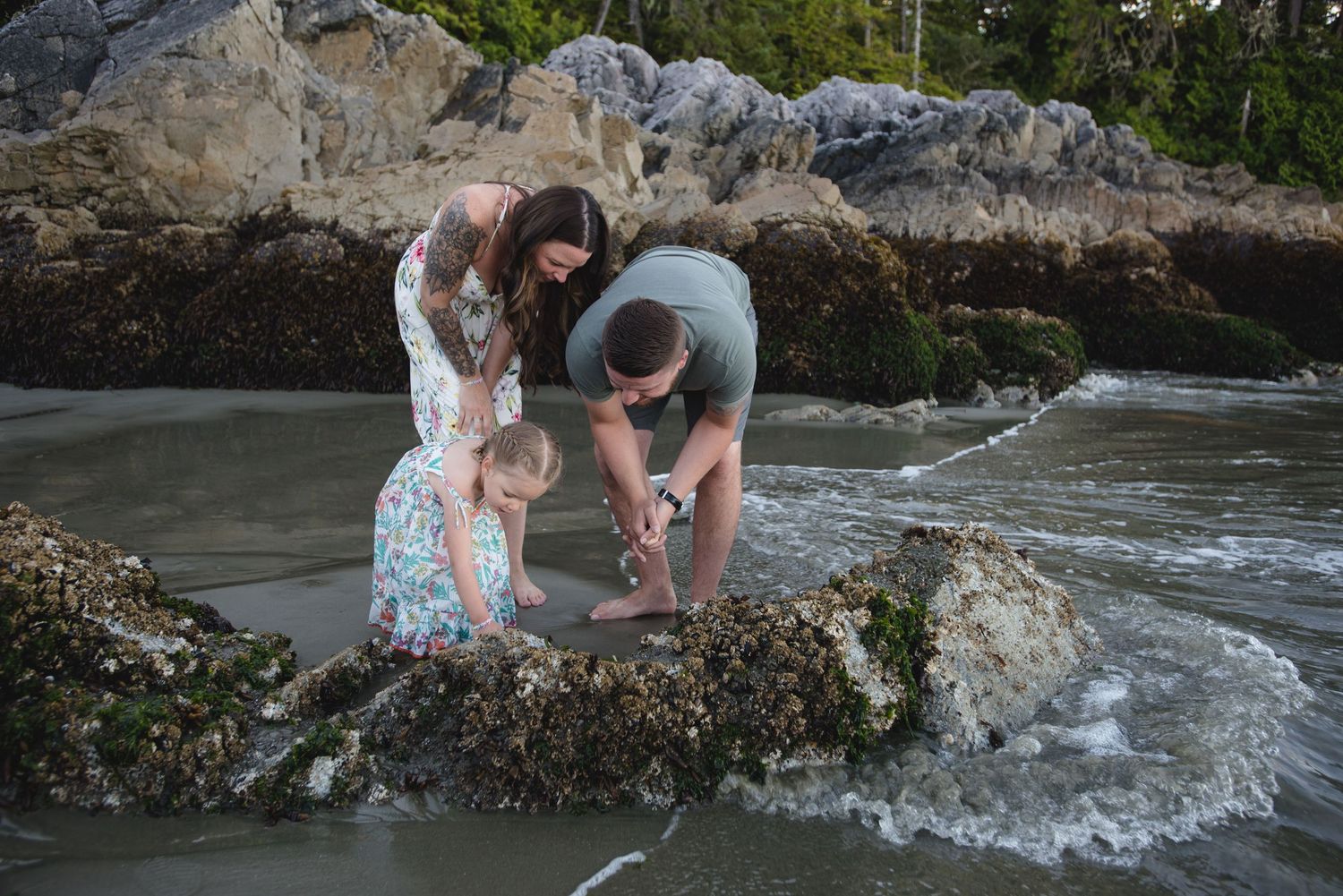 A family exploring tide pools among rocky coastal formations.