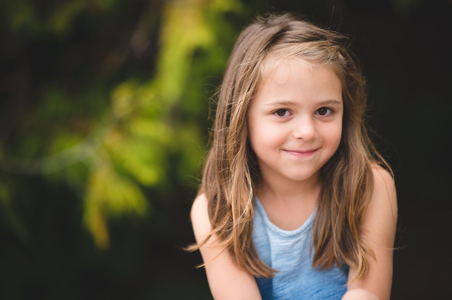A series of close-up portrait shots showing a young girl in a blue top against a blurred natural background.