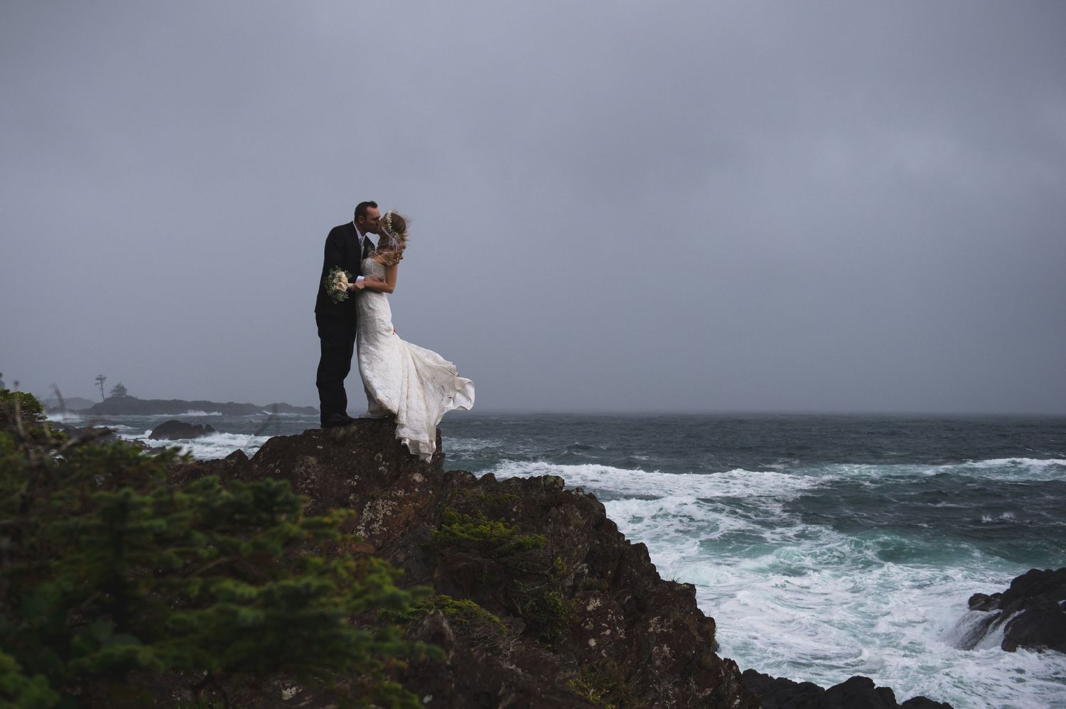Moody grey skies over rocky coastal cliffs with crashing waves.