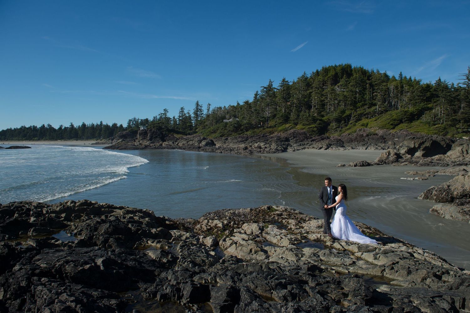 Dramatic coastal landscape with rocky cliffs and beach during a wedding photo session.