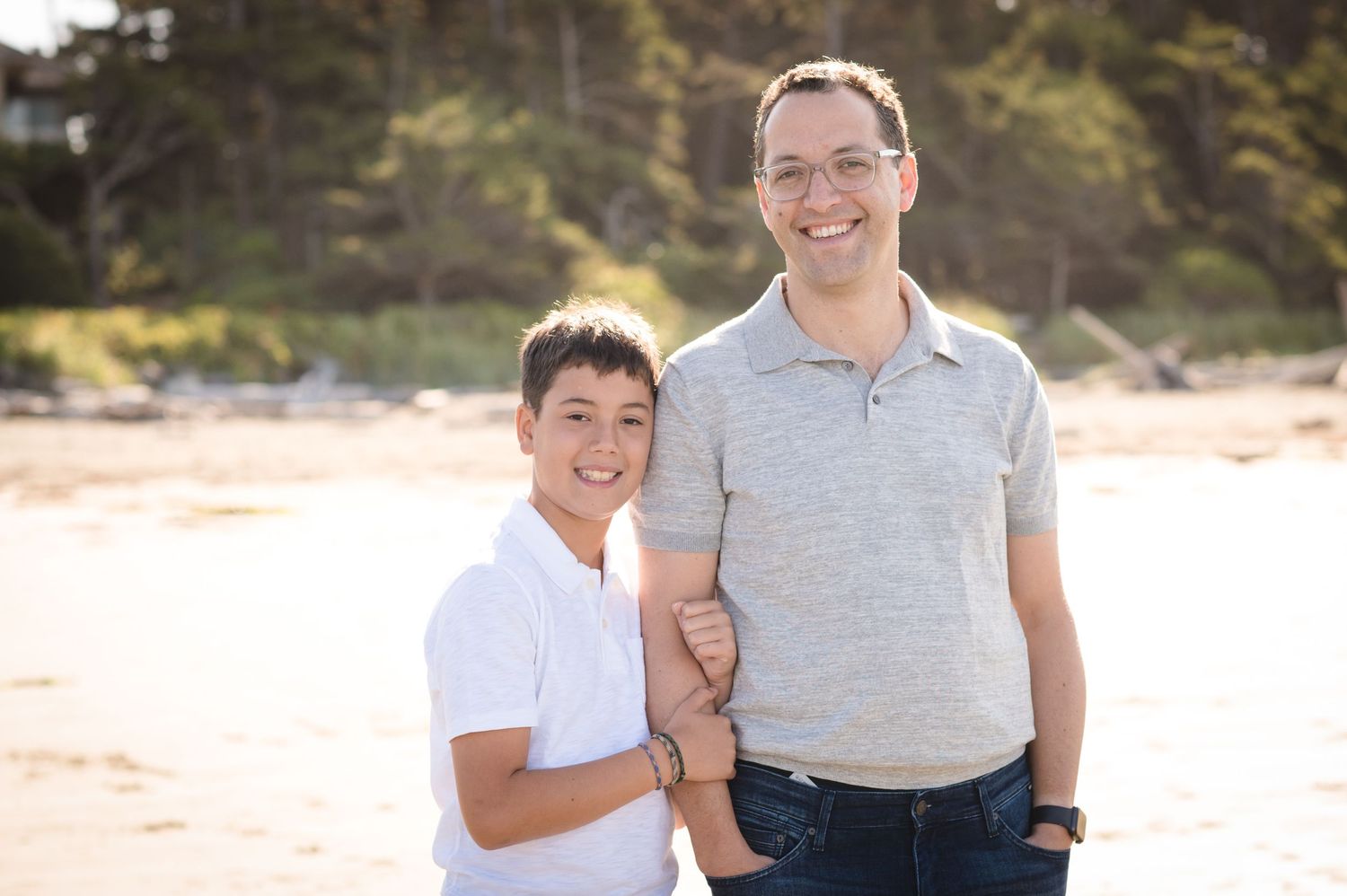 Casual family portraits taken on beach with natural coastal scenery.