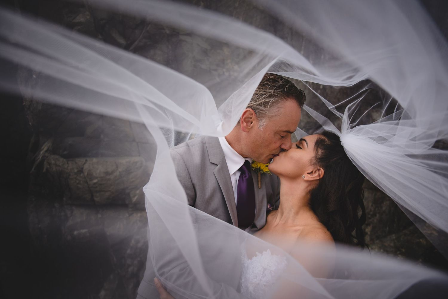 An artistic black and white portrait with flowing white veil creating dreamy movement.