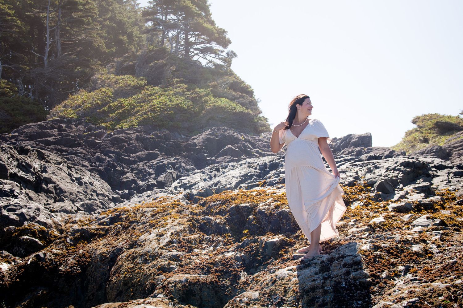 Dramatic maternity photography session on rugged Pacific Northwest coastline.