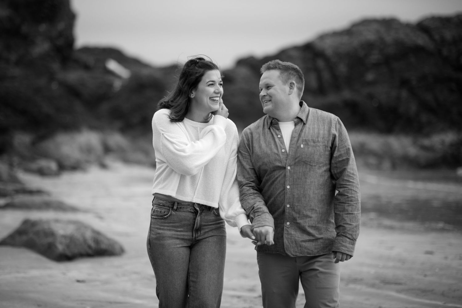 Candid moments captured during a romantic beach engagement session.