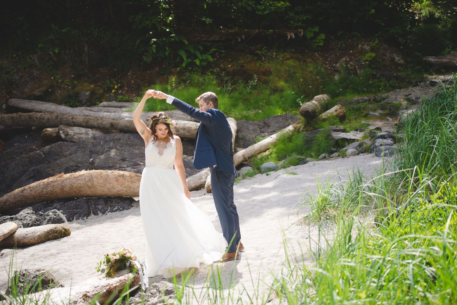 Wedding couple walking along scenic nature path with fallen logs.