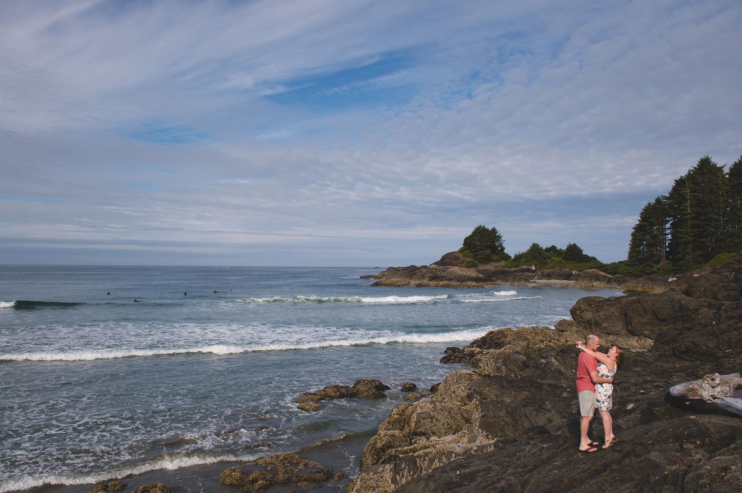 Rocky coastline with crashing waves and rugged cliffs along a scenic ocean shore under cloudy skies.