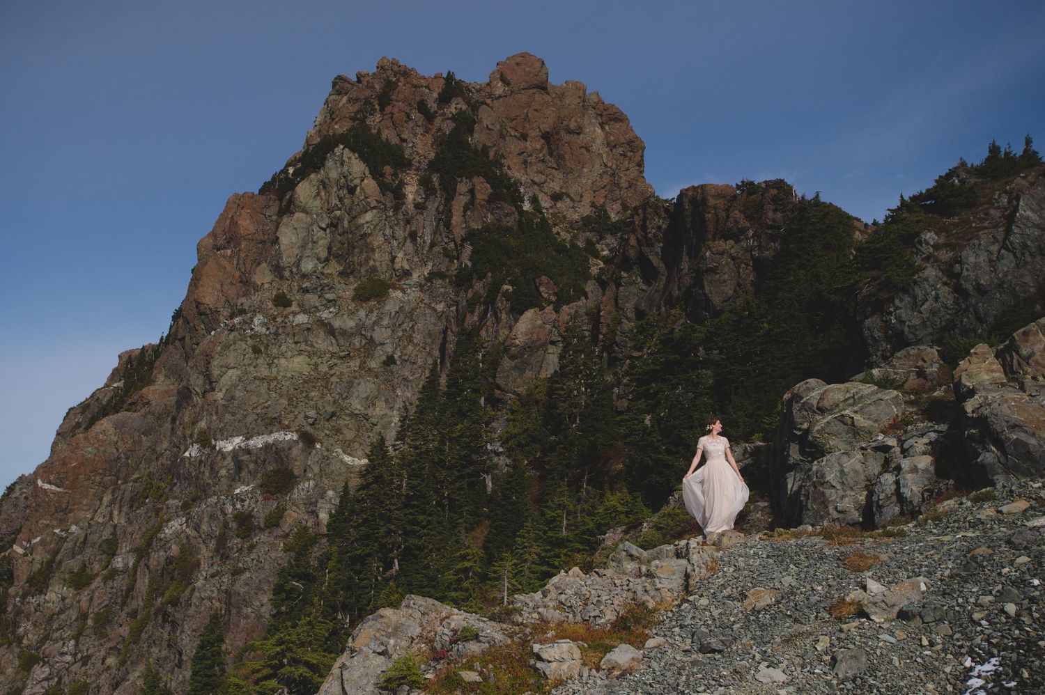Mountain wedding ceremony site with dramatic cliffs and peaks in the background.