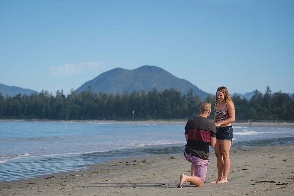 Scenic mountain views and sandy beach coastline on a sunny day in Tofino, British Columbia.